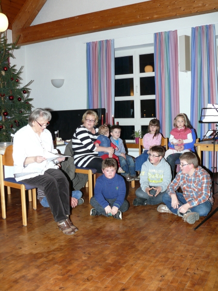 Weihn2013_08.jpg - Die Kinder warten auf den Weiihnachtsmann. Jutta liest noch schnell eine Geschichte vor.
